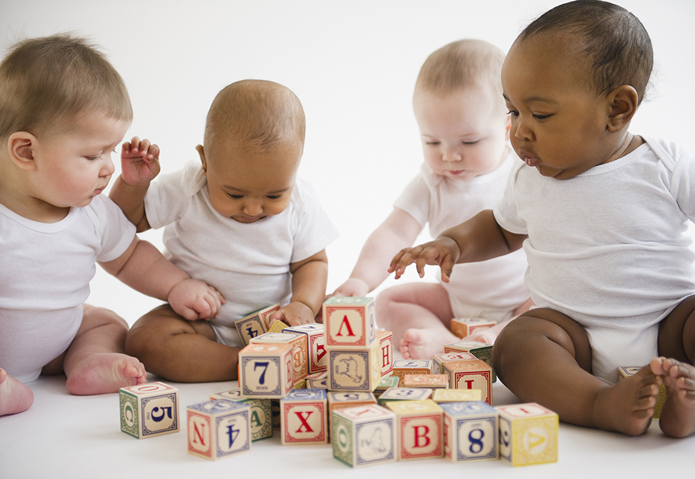 Cztery noworodki bawiące się kockami